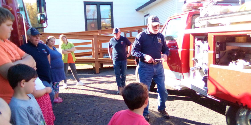 Fire dept. showing the kids some of the equipment on the smaller fire truck. 