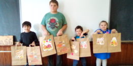 Justin, Reggie, Oliver, and Olivia showing off their thanksgiving bag art work for Little Brothers project.