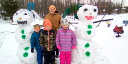 Oliver, Justin, Reggie, and Olivia standing in front of their Frosty and Millie snow people. 2021