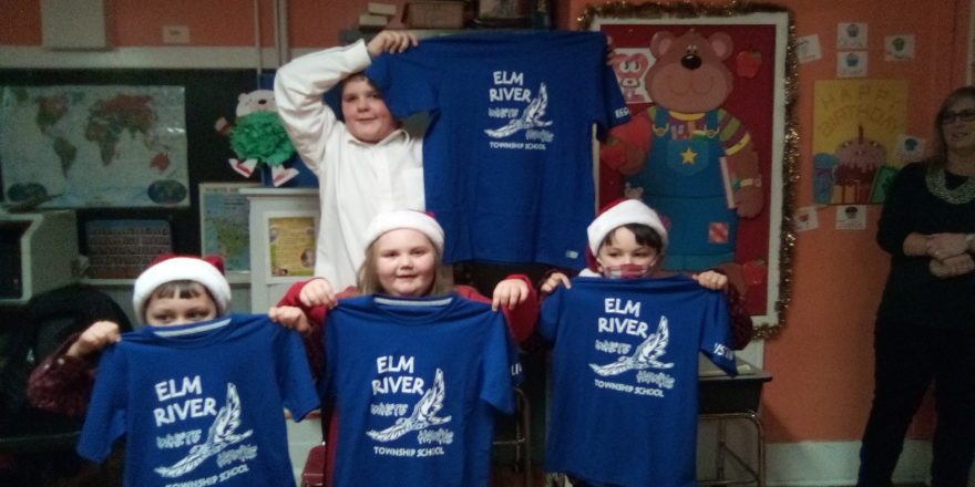 Oliver, Olivia, Justin, and Reggie holding up their new White Hawks shirts