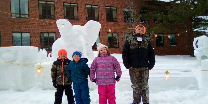 Justin, Oliver, and Olivia standing in front of the elephant snow sculpture at MTU 2022