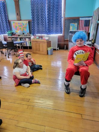 Reggie (thing 1) reading to Olivia, Justin, and Oliver.