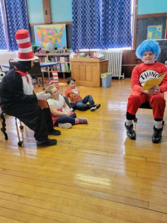 Reggie reading Dr. Seuss book to Mr. Greg ( cat in the hat), Olivia, Justin, and Oliver.