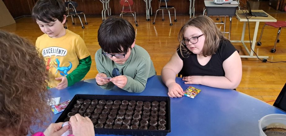 Planting seeds in pods for Earth Day with Oliver, Justin, Olivia, and Ms. J.