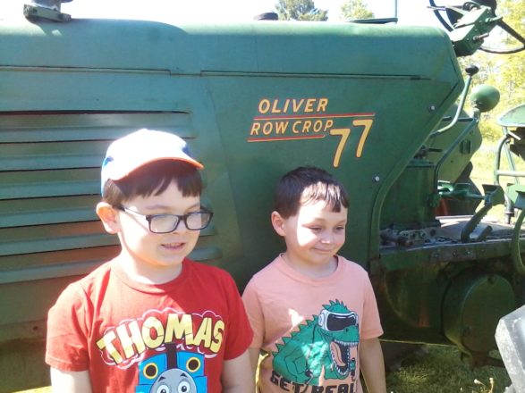 Justin and Oliver standing next to the Oliver tractor at Melody acre stables.