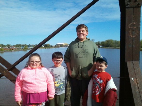 Olivia, Oliver, Reggie, and Justin standing on the Ontonagon train bridge.