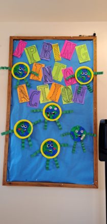 Spring into action with earth day craft plates decorating the entry way bulletin board.