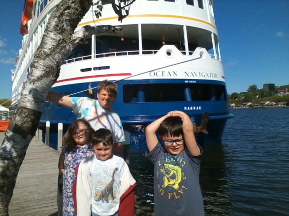 Justin, Oliver, Olivia, and Reggie standing near the cruise ship at the Houghton canal.