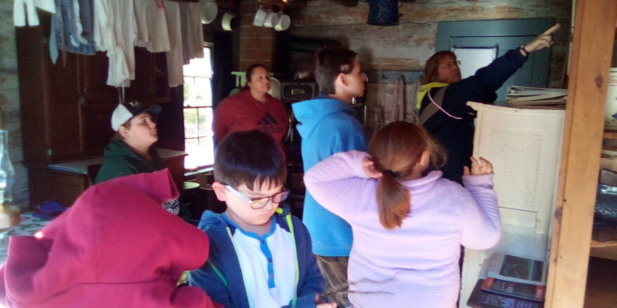 Ms. J. pointing to the map and pictures of the mining site at Old Victoria.