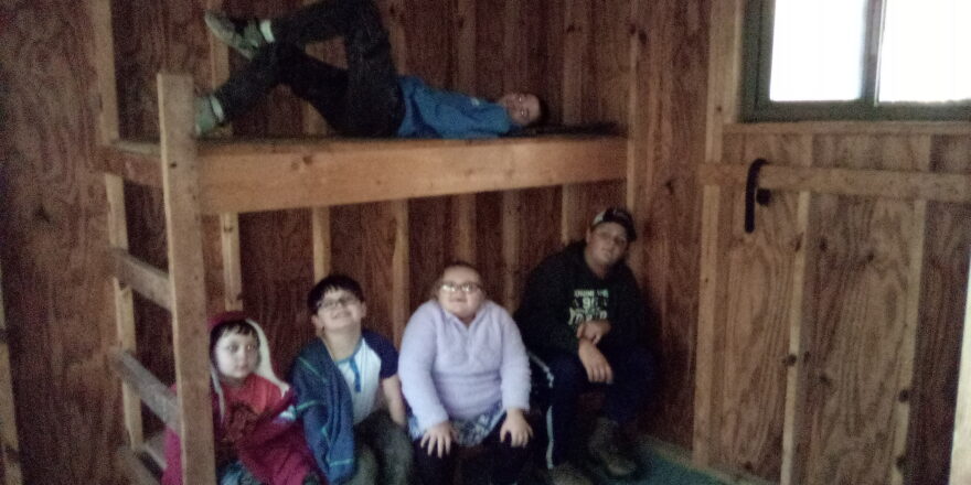 Oliver, Justin, Olivia, Reggie, sitting on bottom bunk and Jacob lying on top bunk of the North Country Trail resting cabin.