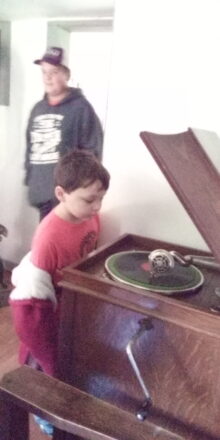 Reggie and Oliver listening to a record on the victrola.