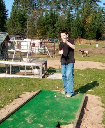 Jacob trying to figure out which way to hold the putter on one of the putting greens at the Hulkkonen Farm.