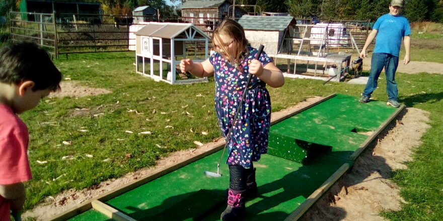 Oliver, Olivia, and Reggie on the putting green at the Hulkkonen Farm.