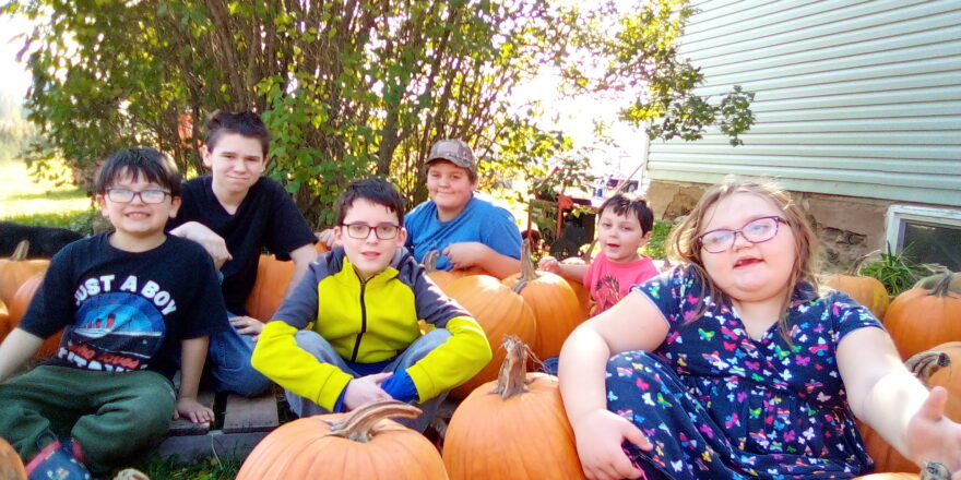 Justin, Jacob, Avery, Reggie, Oliver, and Olivia sitting in with the pumpkins.