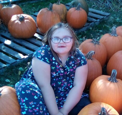 Olivia sitting with the pumpkins.