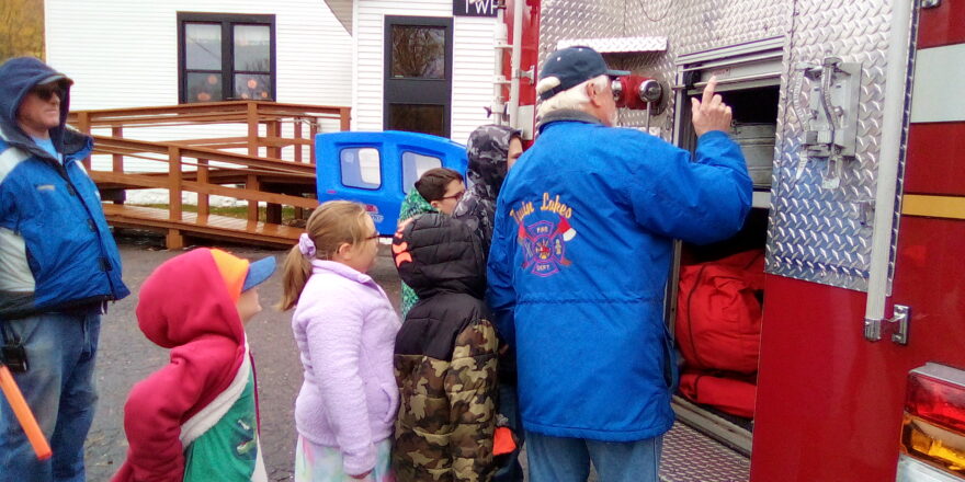 Oliver, Olivia, Justin, Avery, and Jacob looking at fire truck tools.