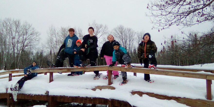 All the school kids lined up on the arched bridge with their snowshoe gear on at the Wyandot Golf Course. 