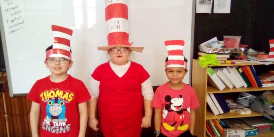 Dr. Seuss red and white tall hats on the 3 little kids for reading month.