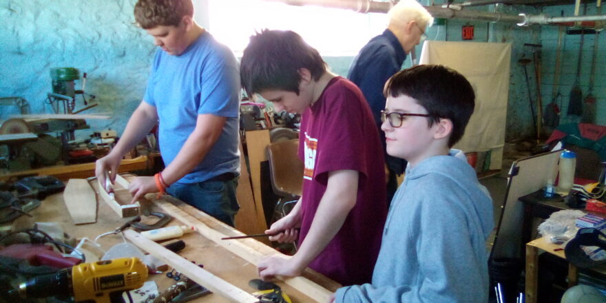 Reggie, Jacob, and Avery working on putting in the frets on their dulcimer necks.