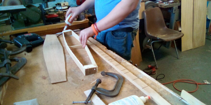 Reggie gluing the sides and top of the dulcimer frame to get ready to attach the top.