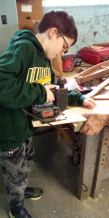 Avery cutting out the top of his dulcimer template with a jigsaw.