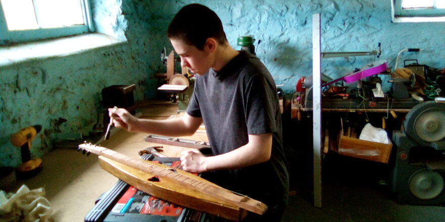 Jacob staining his dulcimer that he just built.