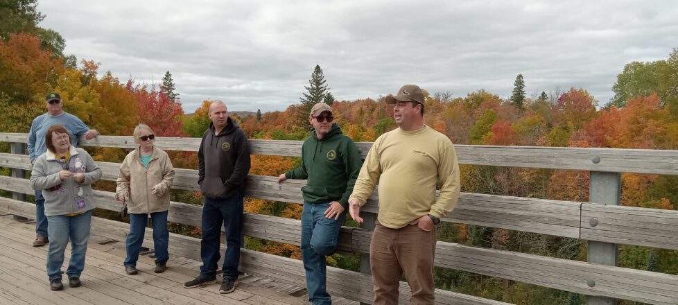 DNR and Tech Employee talking to the school kids about why the leaves change colors and fall off. 