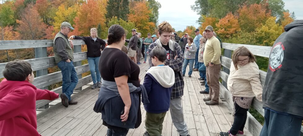 Kids and adults gathering on the Bill Nichols trestle bridge for their info gathering with DNR.