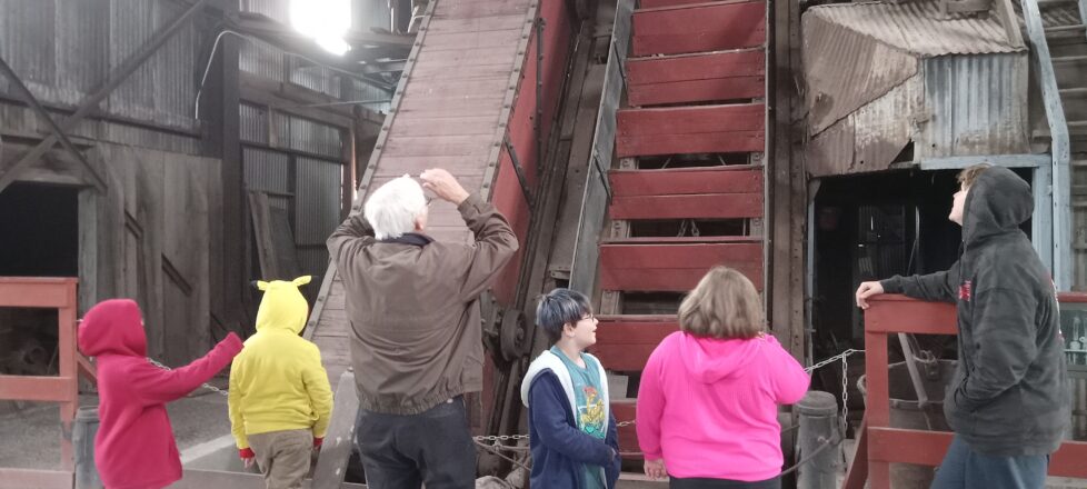 Students looking at a display of where the copper and the workers were hauled up and down the mine shaft.