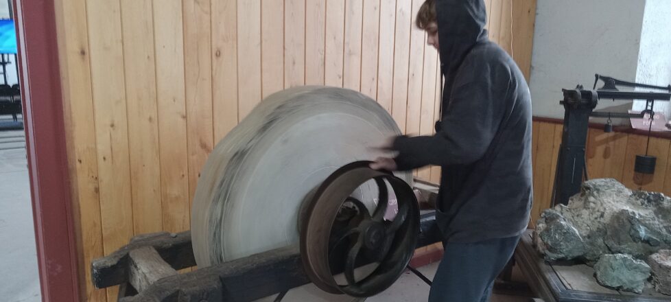 Turning the sharpening stone by a student to see how heavy it is.