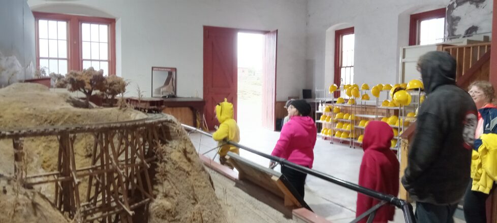 students looking around the model of the mine site and surrounding village. 