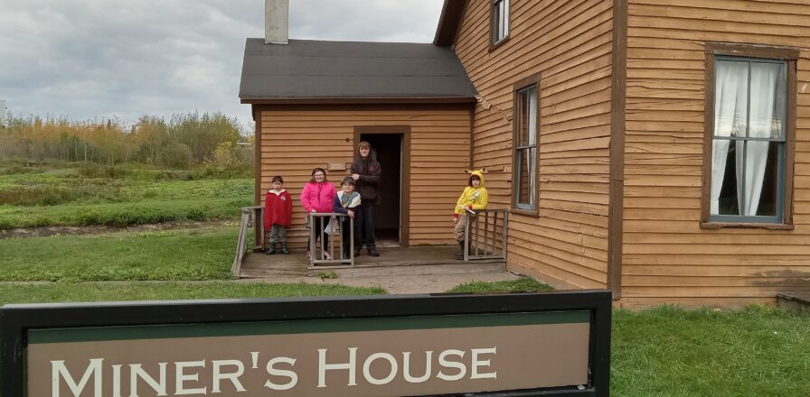 Gathering outside one of the site buildings of a miner's house.