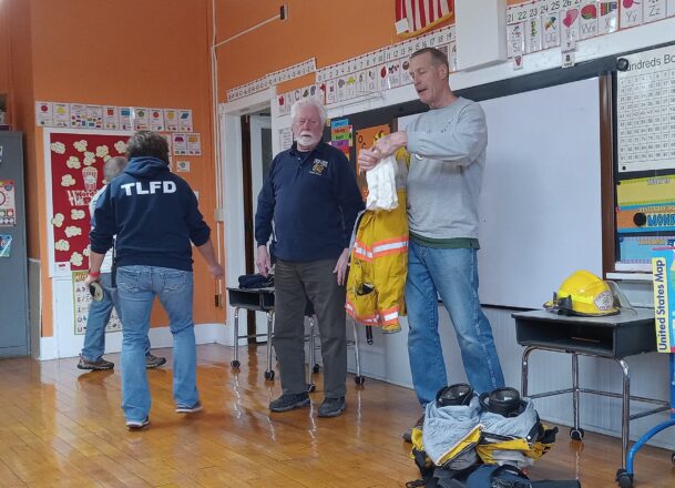 Elm River fire fighters giving a demonstration of their protective equipment.