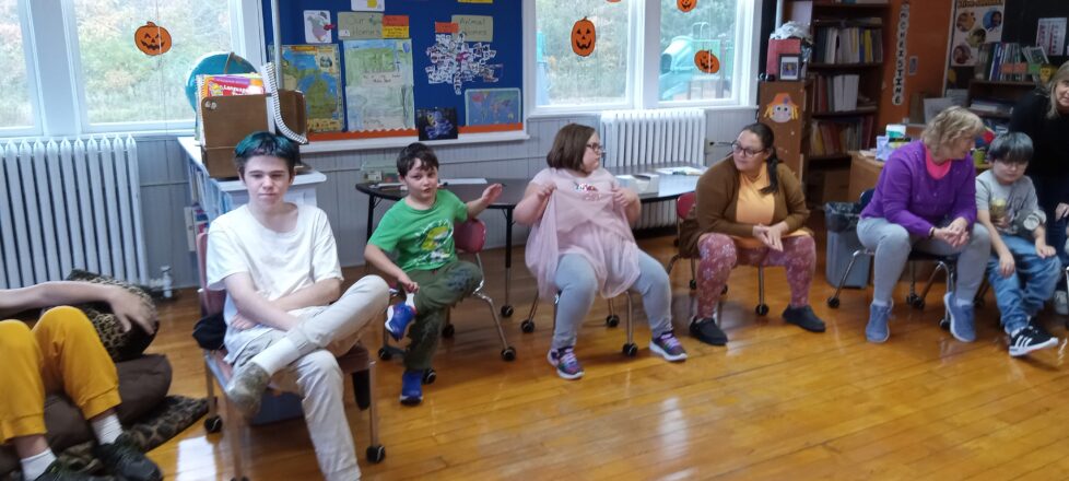 All the students in the class sitting around the fire fighters from Elm River.