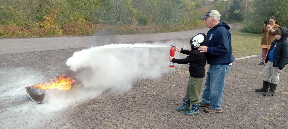 Twin Lakes Fire Department teaching how to spray with a home fire extinguisher.