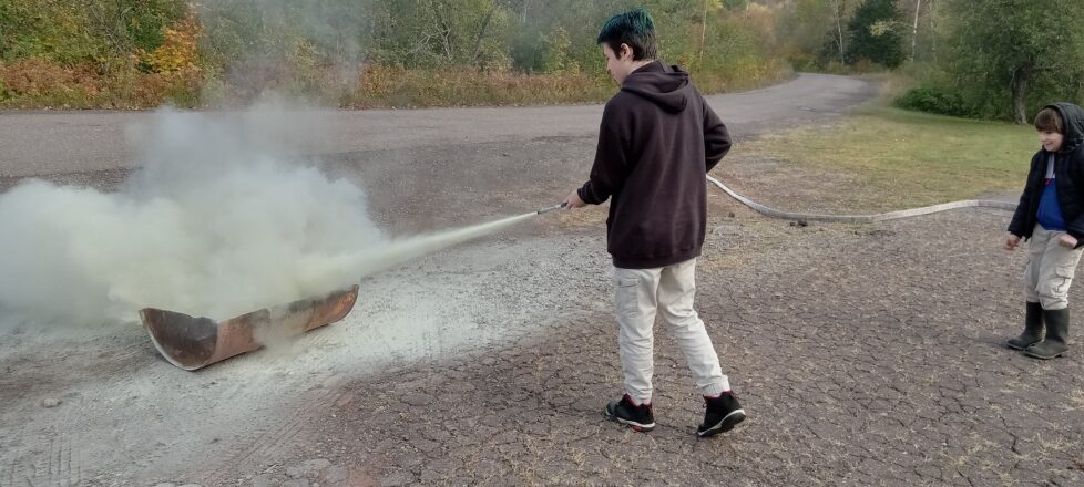 Learning how to point and use a fire extinguisher.