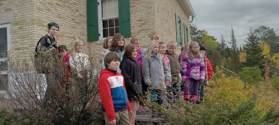 The group of students from the 3 micro schools gather in front of the light house to take a picture.