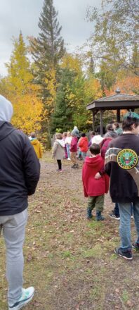 The whole group of student gather around the display outside the Copper Harbor Light House.