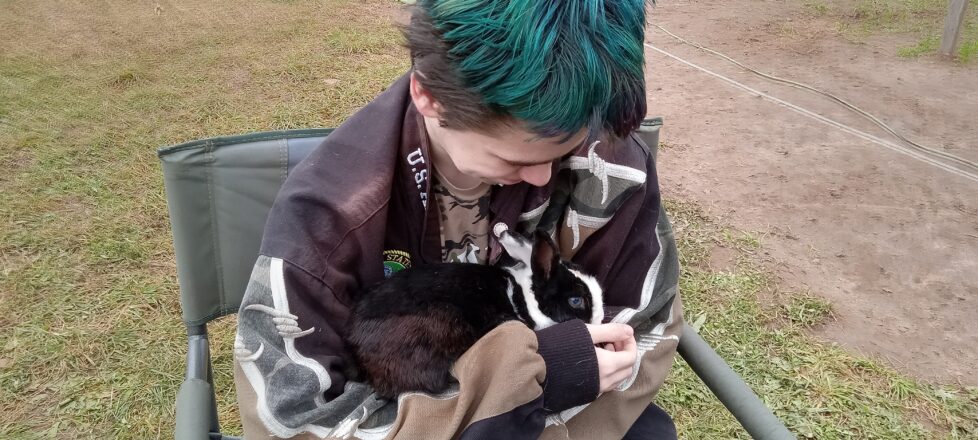 A student is holding a rabbit at Palosaari Corn Maze.