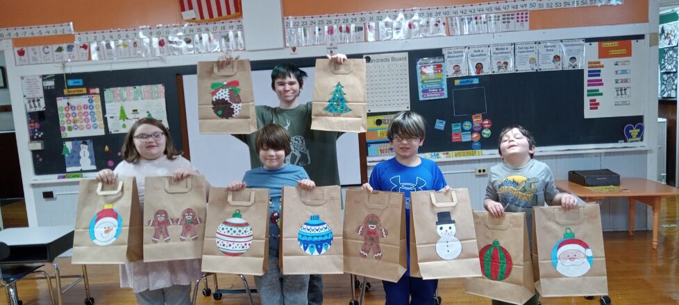 Kids made Christmas bags for friends of the elderly. The bags have a big ornament ball of different colors, some have snowman and some have gingerbread figures, while others have Christmas trees.