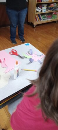 Student making a paper hand with examples of where germs might be hiding. 