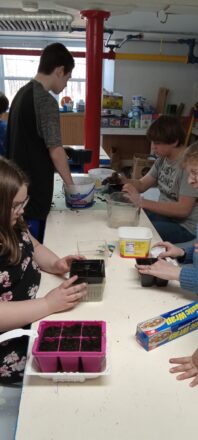 Kids are mixing, adding water and prepping the plant trays for the seeds.